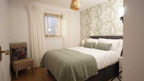 a bedroom with a bed and a window and a chair at Cosy flat in Inverness