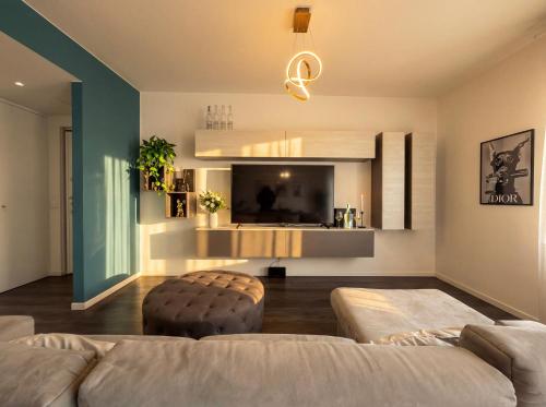 a living room with a couch and a television at Design Penthouse with Balcony - Iseo in Iseo