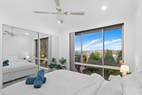 a bedroom with two beds and a large window at Wangi Waters and Views in Wangi Wangi