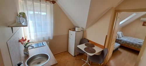 a small bathroom with a sink and a bedroom at Villa Maria in Egerszalók