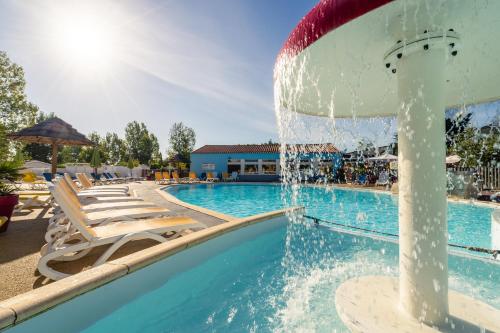 a pool with a water fountain in a resort at Camping Le Bois Soleil - Mobil home 3 pièces 4 personnes + TV MAE-4364 in Les Sables-d'Olonne