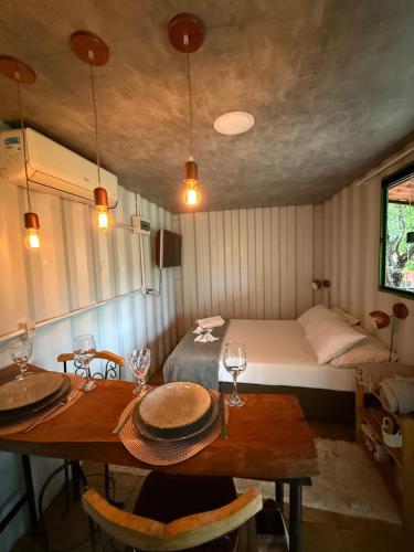 a room with a bed and a table with glasses on it at Cipó Container in Santana do Riacho