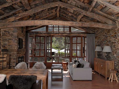 a living room with wooden ceilings and a large window at Aldea Rural y Gastro Restaurante Casona de Labrada in Labrada