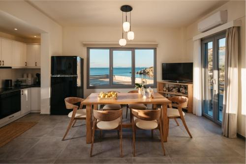 a kitchen and dining room with a table and a view of the ocean at Irini's Beach House in Ambrami