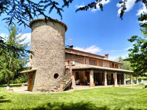 a large stone building with a tower on top of it at Villa Montegenco B&B in Comunanza