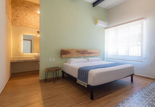 a bedroom with a bed and a large window at Casa Talavera, Tu Casa en Mérida in Mérida