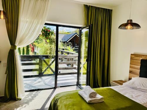 a bedroom with a bed and a sliding glass door at Jazz House in Voroneţ