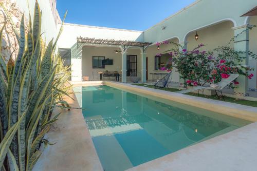 a swimming pool in front of a house at Casa Talavera, Tu Casa en Mérida in Mérida