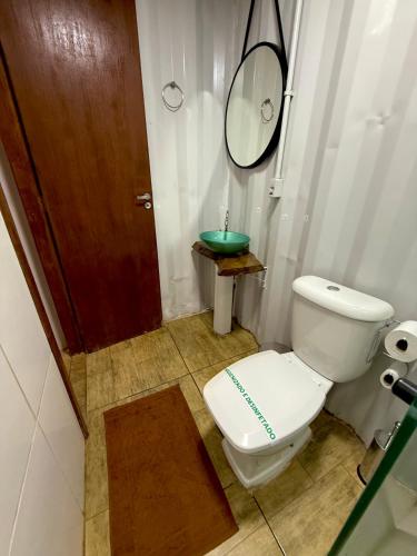a bathroom with a toilet and a mirror and a sink at Cipó Container in Santana do Riacho