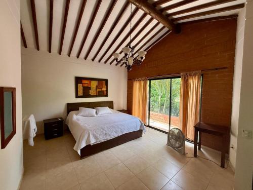 a bedroom with a bed and a large window at El Encanto in Olaya