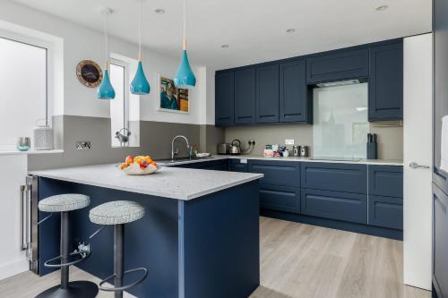 a kitchen with navy blue cabinets and a counter top at Middle Chine - Beautiful Garden and Spacious Living Space in Bournemouth
