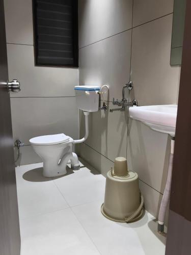 a bathroom with a toilet and a sink at Hotel Atithi Lodging Pune in Pune