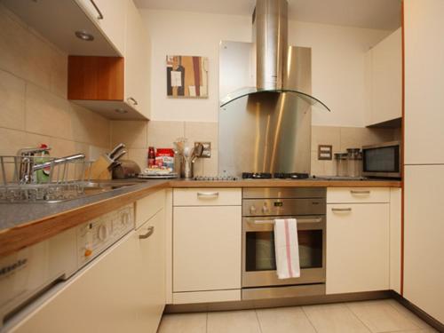 a kitchen with white cabinets and a stove top oven at Marina Secret - on Poole Quay with Free Parking in Poole