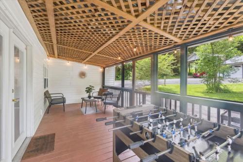 a screened porch with tables and chairs and windows at Creekside Retreat by Beyond Expectations in Pigeon Forge