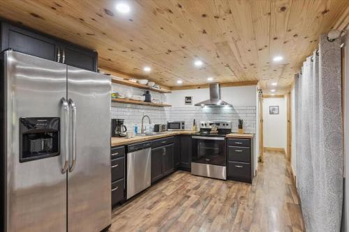 a kitchen with stainless steel appliances and a wooden ceiling at Creekside Retreat by Beyond Expectations in Pigeon Forge