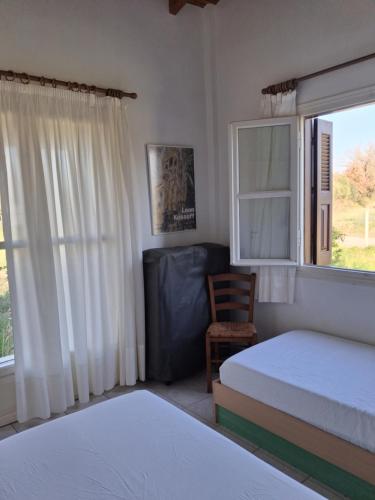 a bedroom with two beds and a window and a chair at tragano in Traganón
