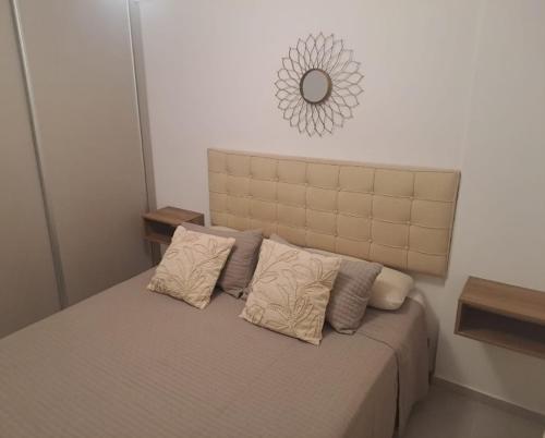a bed with two pillows and a mirror on the wall at Departamento equipado en el macrocentro santa fe in Santa Fe