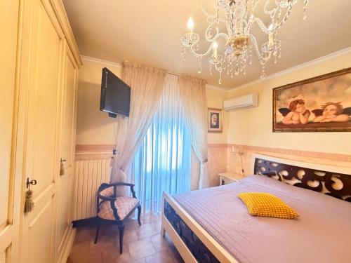 a bedroom with a large bed and a chandelier at Art & Relax House in Gallipoli