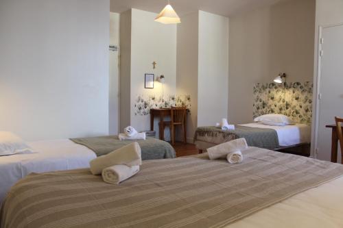 a hotel room with two beds and a table at Le grand couvent de Gramat in Gramat