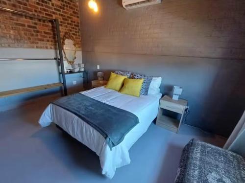 a bedroom with a bed and a brick wall at Luxurious and spacious 2 level apartment in Tygerberg Hills