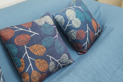 two pillows sitting on top of a blue couch at Northern Breeze Comfort in Ribeira Grande