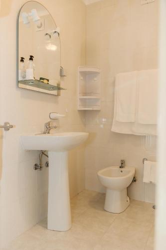 a white bathroom with a sink and a toilet at Northern Breeze Comfort in Ribeira Grande