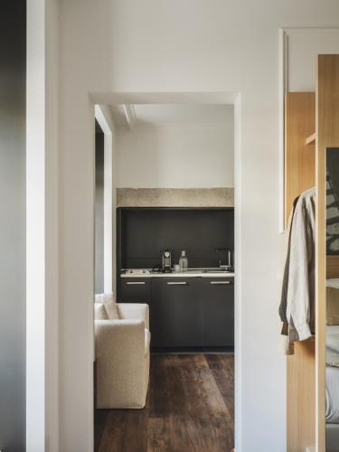 a kitchen and living room with a couch and a chair at Casa Solayme Garrett in Lisbon