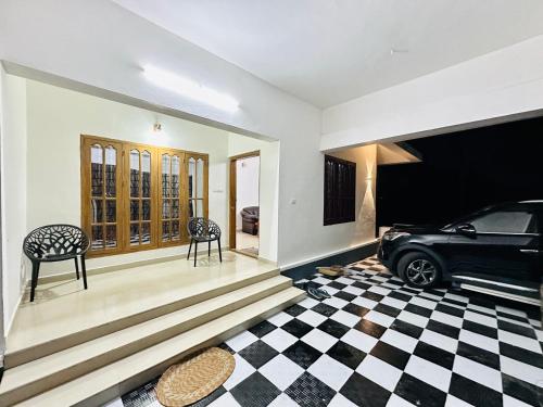 a car parked in a room with a checkered floor at Richards Shared Apartment-AC in Thiruvalla