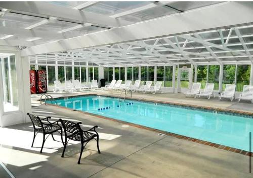a large swimming pool with chairs and a swimming pool at Mountain View Condo by Beyond Expectations in Pigeon Forge