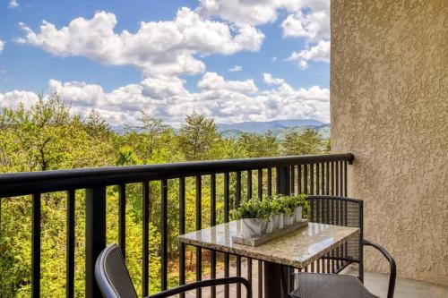 a table and chairs on a balcony with a view at Mountain View Condo by Beyond Expectations in Pigeon Forge