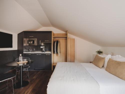 une chambre avec un grand lit blanc et une cuisine dans l'établissement Casa Solayme Garrett, à Lisbonne