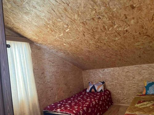 a bed in a room with a ceiling at Raul Lushnu Darbaz in Mestia