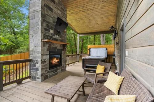 a patio with a fireplace and a grill at Escape to Tranquility - Hot Tub - BBQ - Pets in Broken Bow