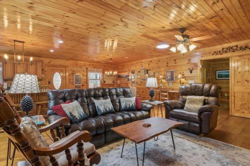 a living room with leather furniture and a wooden ceiling at Chasing Cubs Cabin by Beyond Expectations in Sevierville