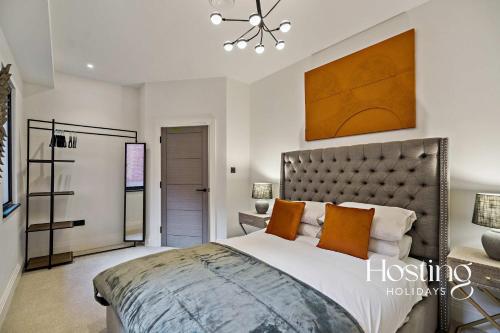 a bedroom with a large bed with orange pillows at Platform One Apartments - Caversham in Reading