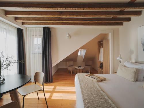 a bedroom with a white bed and a table and chairs at Casa Solayme Vitória in Lisbon