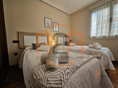 a bedroom with two beds and two mirrors at R2R - El Raitán - 1A122 in Gijón