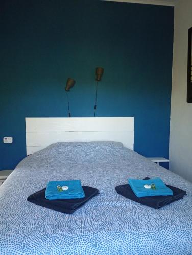 a bed with two blue towels on top of it at Finca el Gaudi, casita Catharina in L'Ampolla