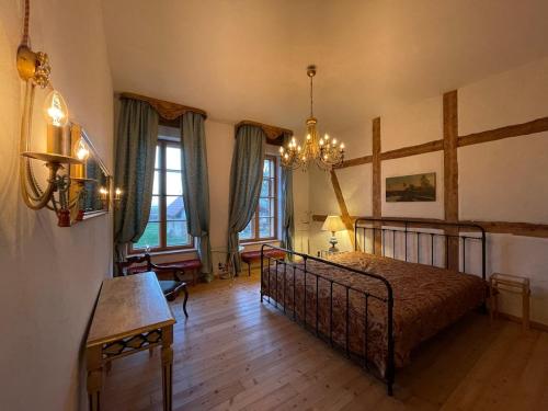 a bedroom with a bed and a chandelier at Die Orchidee - Gutshaus Bückling in Rambin