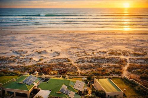 an aerial view of a beach with a house and the ocean at 14 Penguin Place, Melkbosstrand in Melkbosstrand