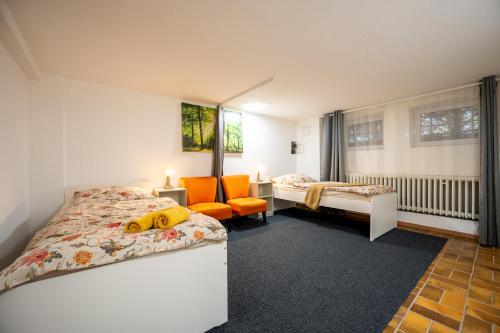 a bedroom with two beds and an orange chair at Space Comfort Bremen Apartment bis zu 5 Personen in Bremen