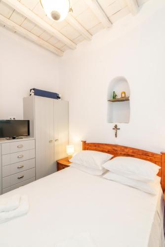 a white bedroom with a bed and a tv at Axas House in Stení