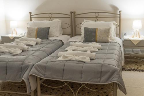 two beds with towels on top of them in a bedroom at Aioliana Apartments in Mytilene