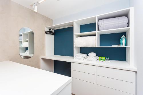 a bathroom with blue walls and white shelves at Galeria Tijucas in Curitiba