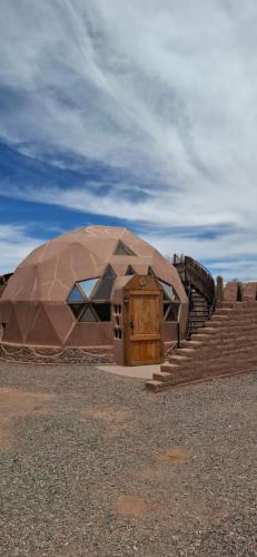 a large dome building with a door and stairs at Domo del desierto in San Pedro de Atacama