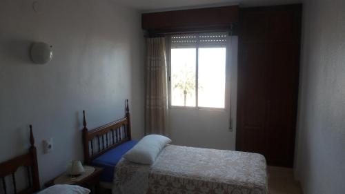 a bedroom with two beds and a window at Primera línea Playa Gandia in Gandía