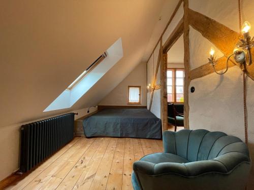 a bedroom with a bed and a couch in a attic at Die Perle - Gutshaus Bückling in Rambin