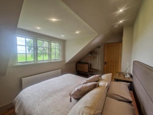 a bedroom with a bed and a couch and windows at Broadmoor Chapel in Hereford