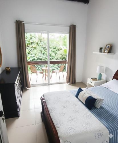 a bedroom with a bed and a large window at Mini Bamboo Nest con Desayuno in Puyo