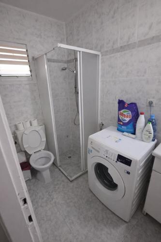 a bathroom with a washing machine and a toilet at Obtsinsky Beach in Haifa